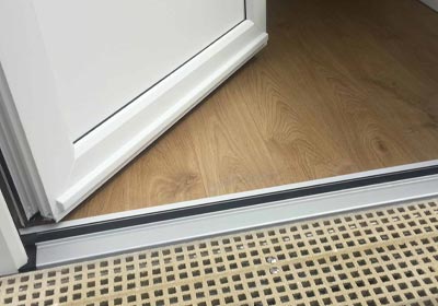 UK homeowner checking durable door thresholds for a secure entryway